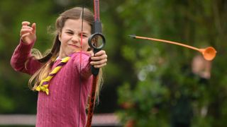 Princess Charlotte of Wales tries her hand at archery while taking part in the Big Help Out, during a visit to the 3rd Upton Scouts Hut in Slough on May 8, 2023 in London, England