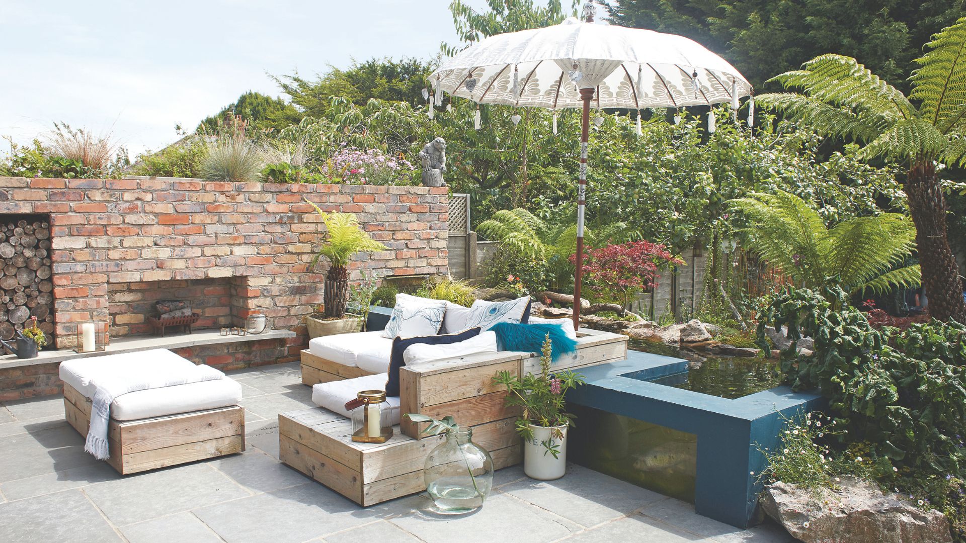 picture of garden with large furniture set, parasol and palm trees