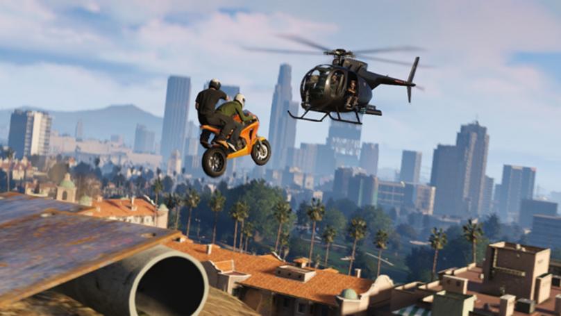 Grand Theft Auto 5 - Two players on a motorcycle jump off a ramp towards a helicopter