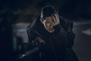 Bae Hyeon-seong as Seung-jo, holding his hand over his bloody eye, in Gyeongseong Creature S2.