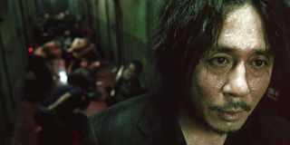 Oh Dae-su (Choi Min-sik) after punching and kicking through a hallway in Oldboy