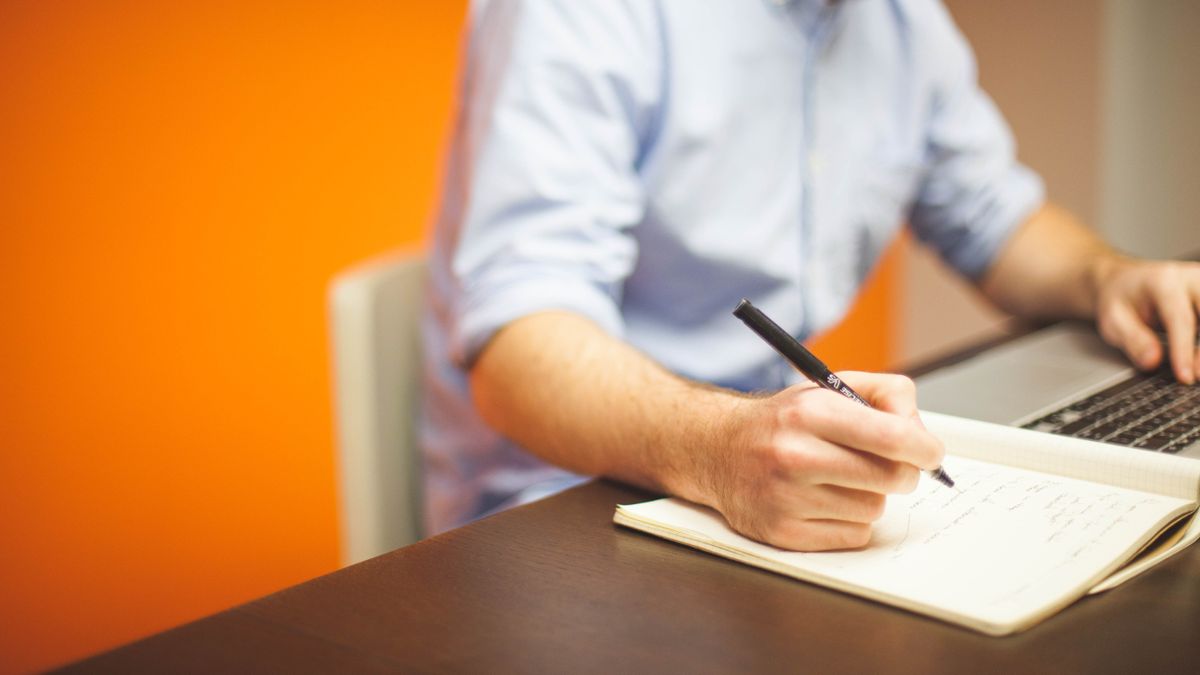 Man holding a pen to paper