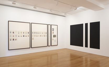 Installation view of four black square and rectangular frames with images of portraits inside. 