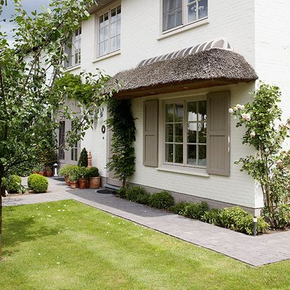 house exterior with white wall and lawn area