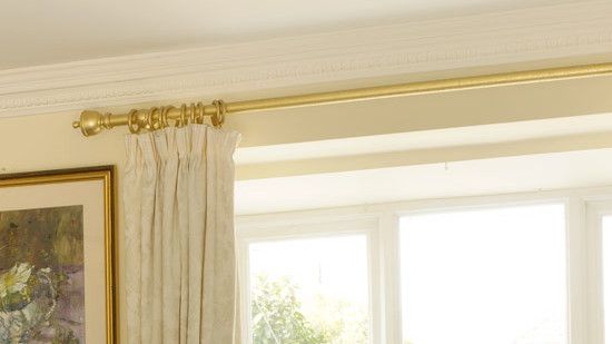 rose ceiling with golden curtain rod and white window