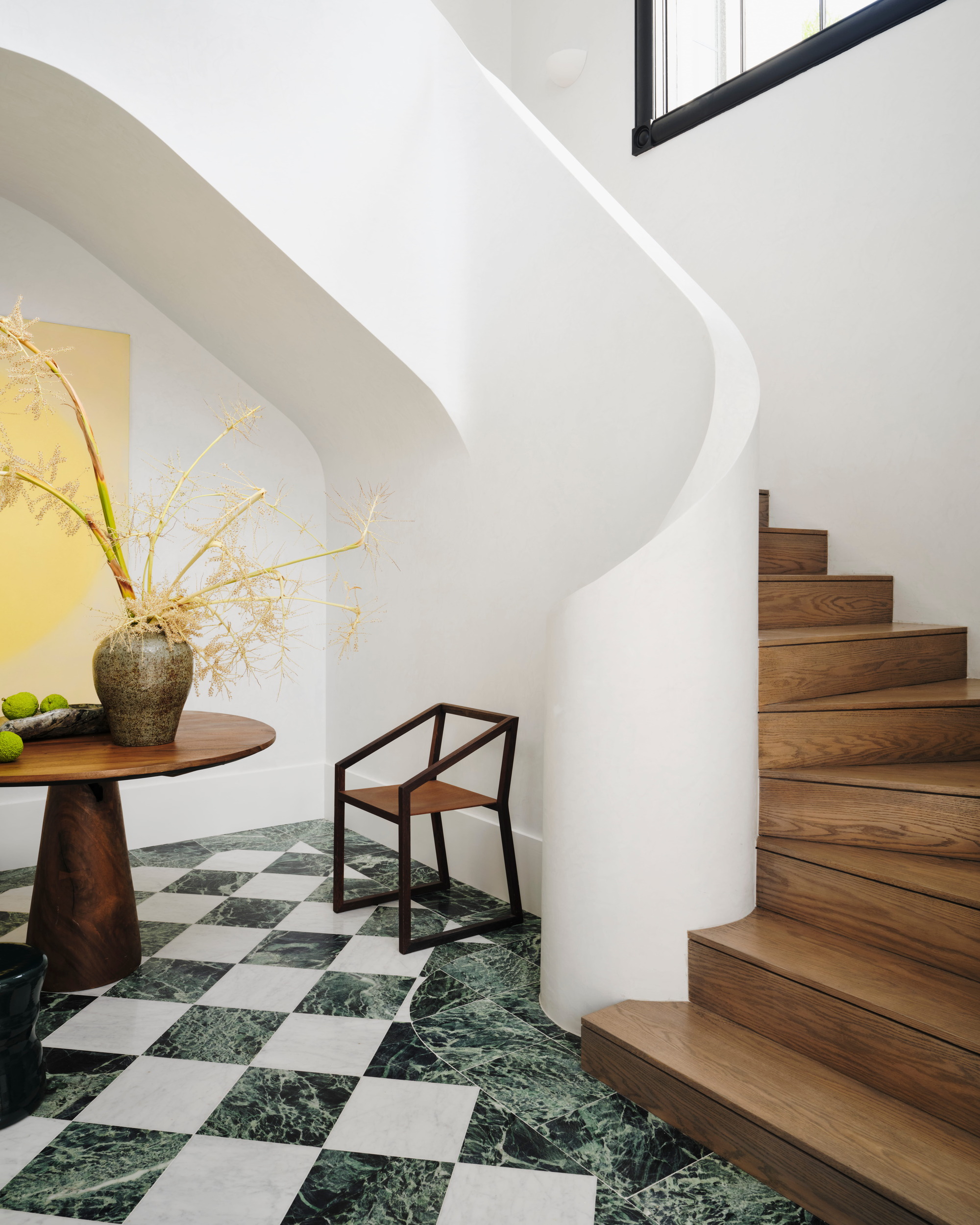 entryway with checkerboard flooring and curved timber staircase