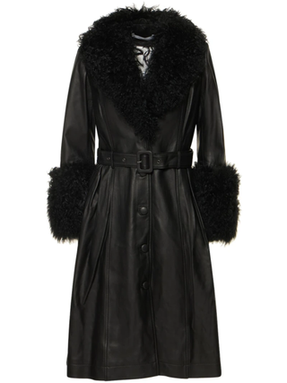 a black Saks Potts coat with fur trim in front of a plain backdrop