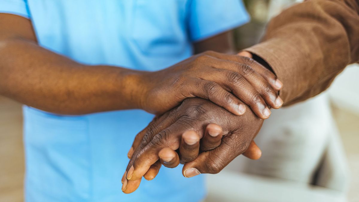 carer holding a patient&#039;s hand