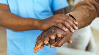 carer holding a patient's hand