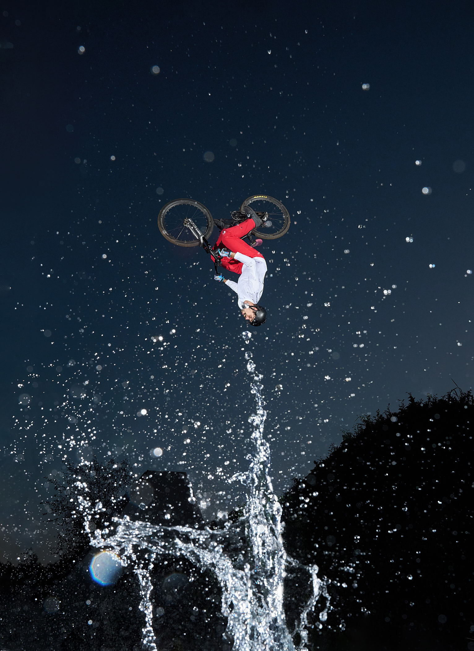 A photograph by Volodya Voronin of a BMX rider flipping over a splash of water