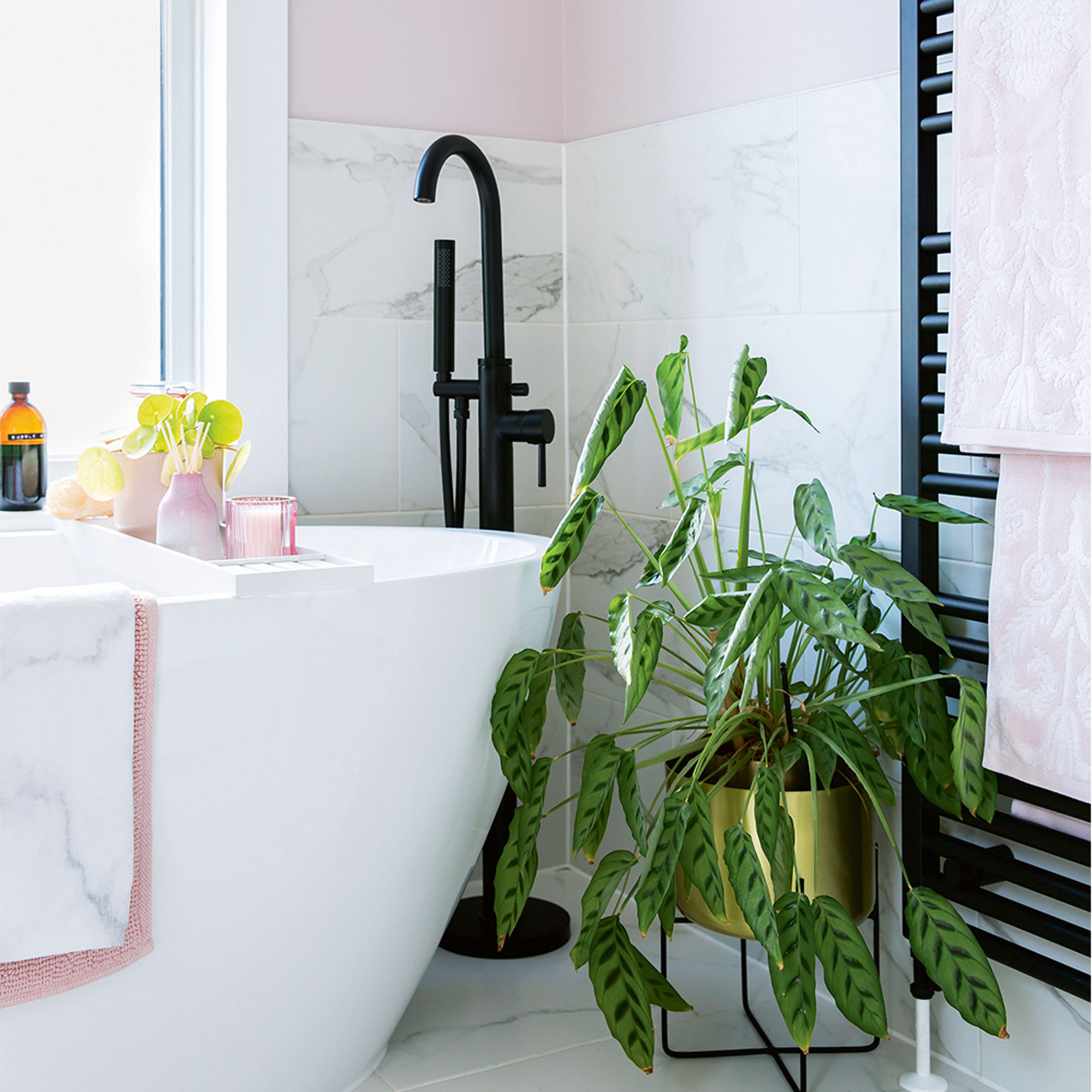 Pink bathroom with freestanding bath and black radiator