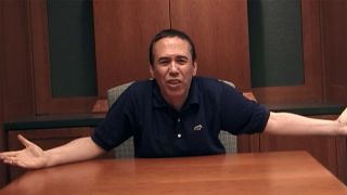 Gilbert Gottfried in a blue shirt with his arms out to his sides in The Aristocrats