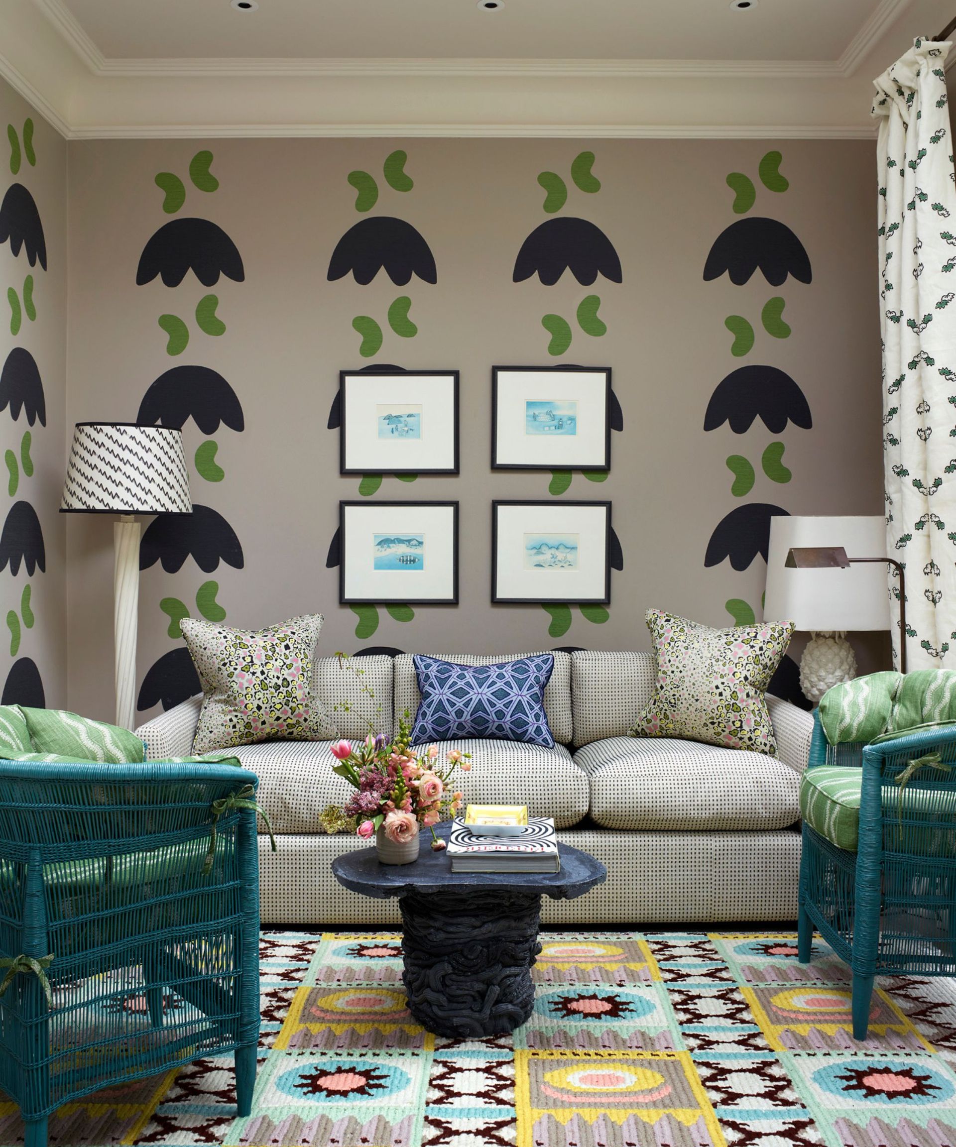 Pink wallpaper with black and pink design, green and blue armchairs