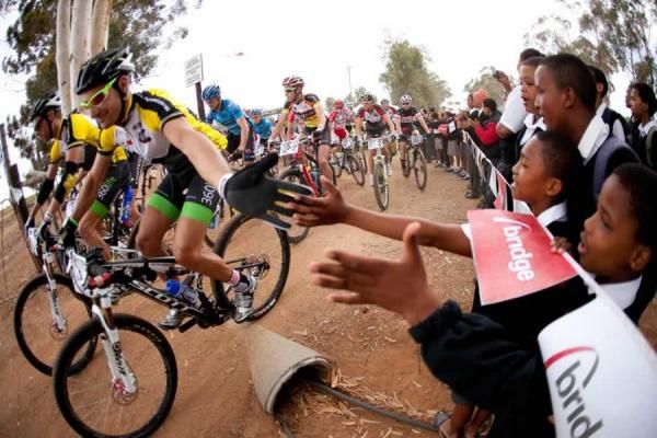 Cheered by local school children, race leaders Kevin Evans (nearest camera) and David George (Nedbank 360Life) lead the field off the start line