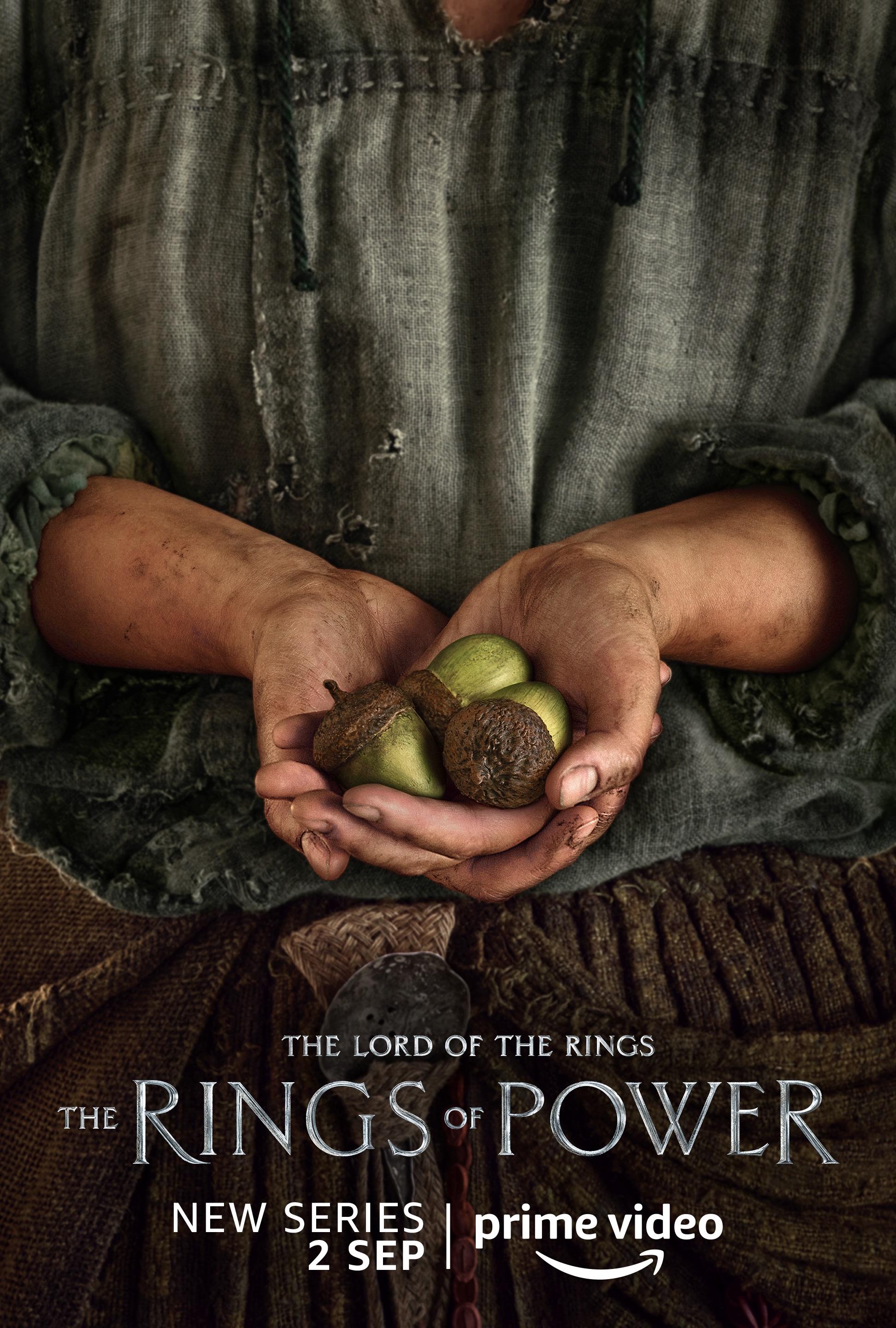 A person holding some acorns character poster for Lord of the Rings: The Rings of Power