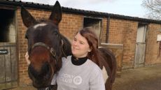 A girl hugging a coloured horse