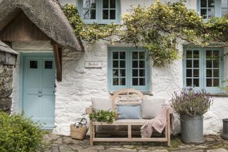 front door to cottage with thatched pitched canopy
