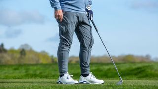 A golfer poses in the Peter Millar Atlas Performance Pant