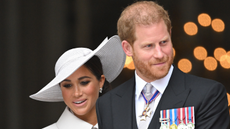 Prine Harry stands next to wife Meghan Markle