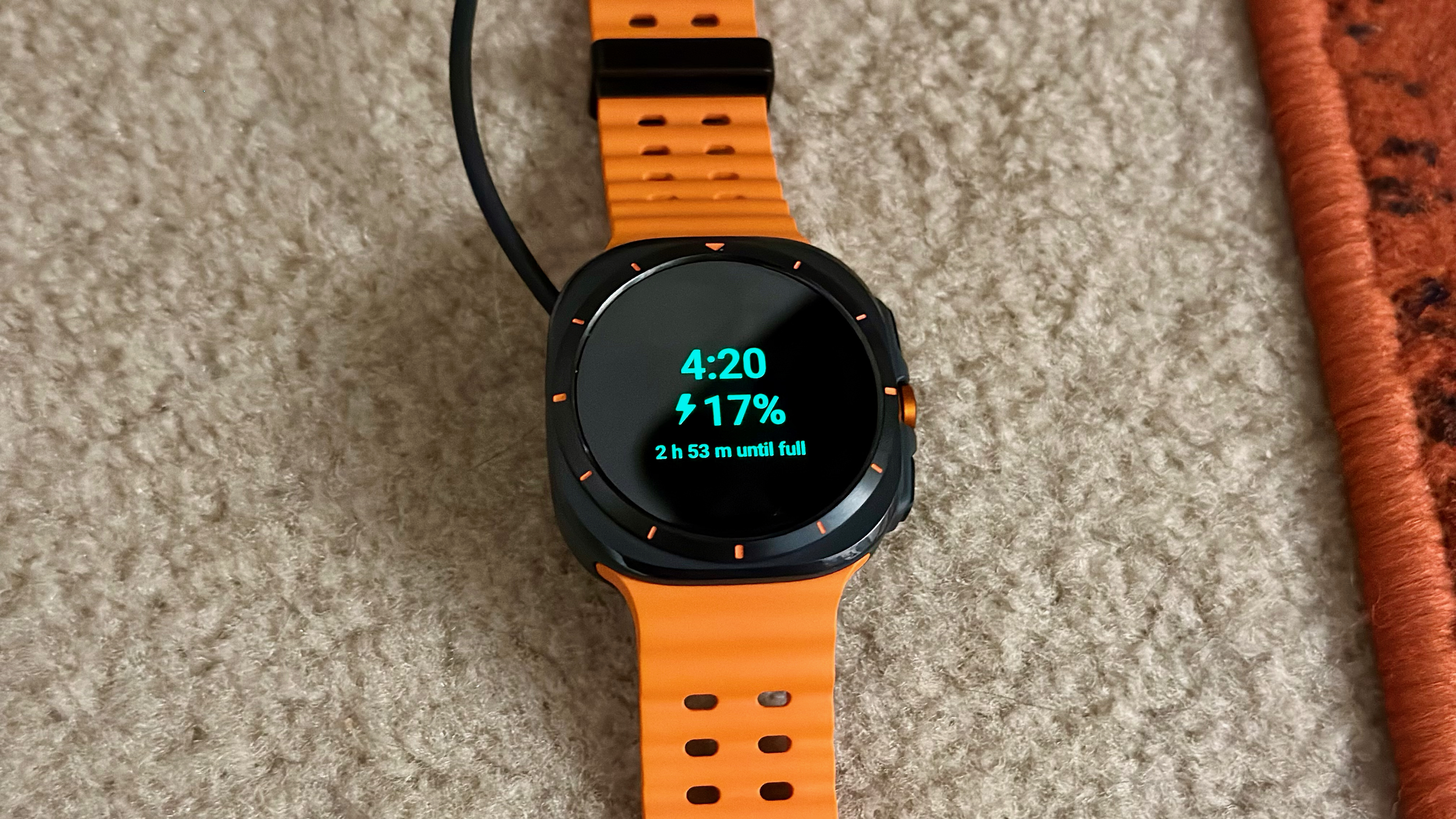 The Samsung Galaxy Watch Ultra sitting on a charging puck at 17% power.