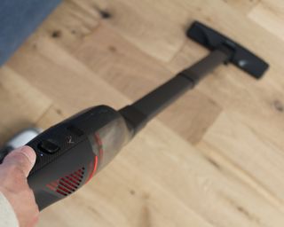 A close-up aerial view of the Eufy HomeVac H30 vacuum being used on laminate flooring