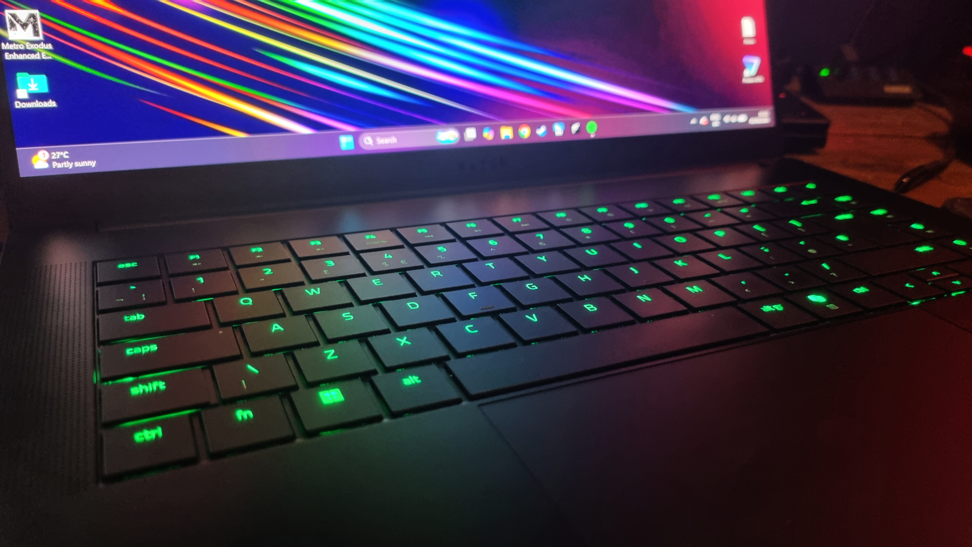 The keyboard of the Razer Blade 16 (2026) gaming laptop, lit up in green