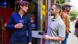 Theo and his ex looking sternly at one another outside a bar. 