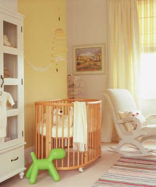 A nursery room painted in pale yellow with white dot motif