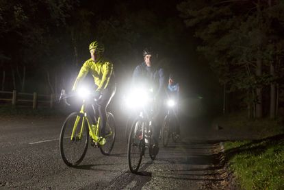 best bike lights Group of cyclists riding on an unlit road with bike lights