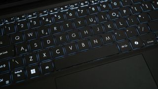 Close up of the keyboard on an Asus ProArt PZ13 laptop on a wooden table