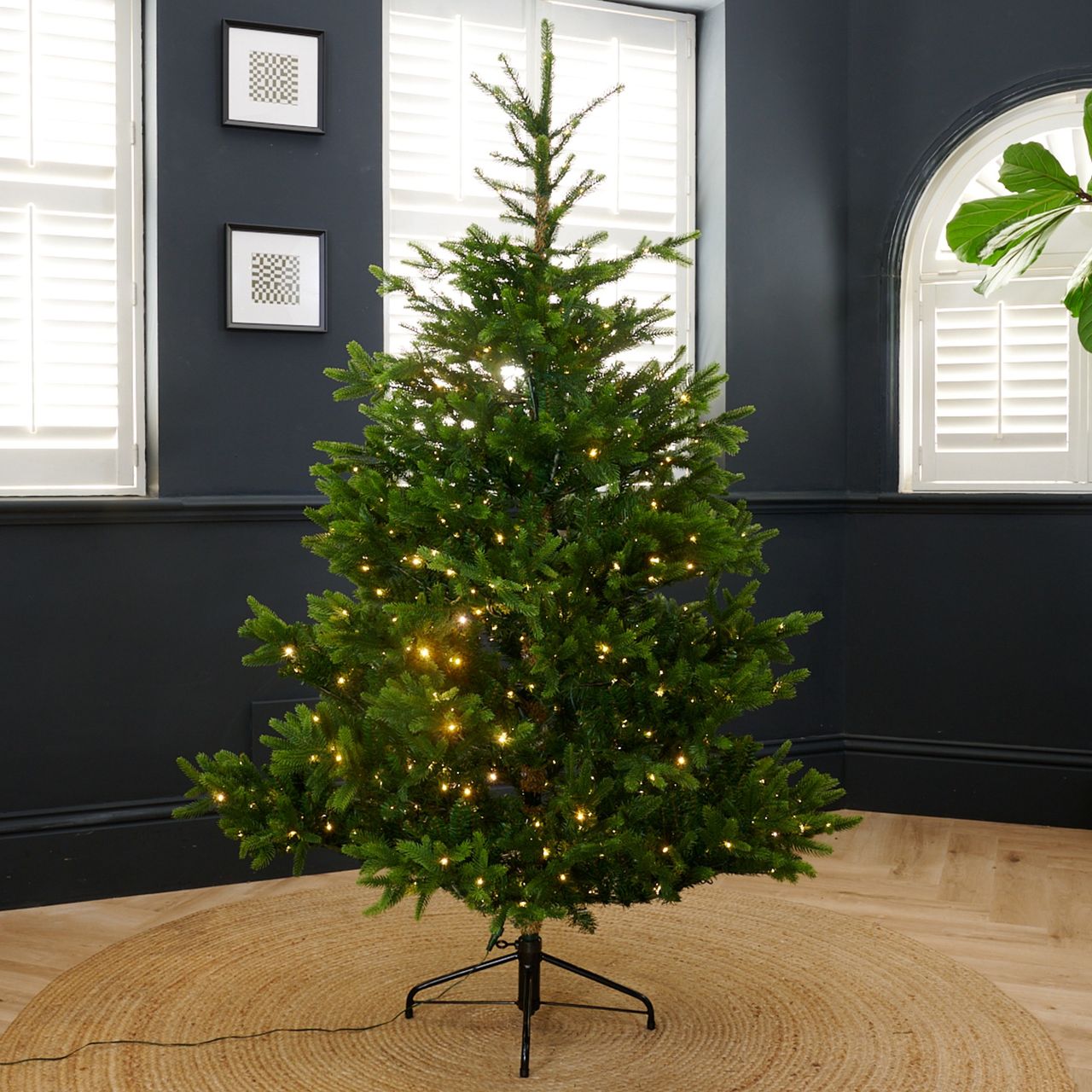 Neptune's Windsor 6ft Pre-lit Christmas Tree set up in a black-painted living room
