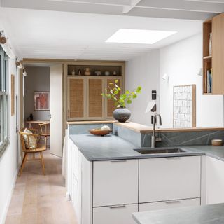 kitchen with white cabinets, grey worktops, and breakfast bar