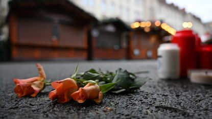 Flowers and candles placed outside closed Christmas market stalls in memory of the victims of a car-ramming attack in Magdeburg