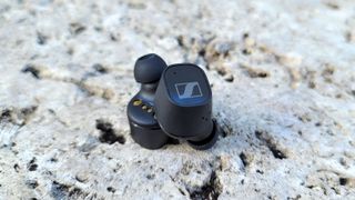 The Sennheiser CX Plus wireless earbuds placed on the concrete