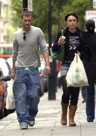 Jamie Dornan and Keira Knightley walk down the street with grocery bags.