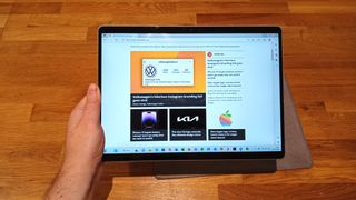 Microsoft Surface Pro 9 review; a hand holds a tablet computer