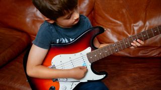 Child plays guitar