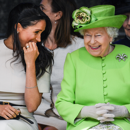 Queen Elizabeth II sitts and laughs with Meghan, Duchess of Sussex during a ceremony to open the new Mersey Gateway Bridge on June 14, 2018 in the town of Widnes in Halton, Cheshire, England