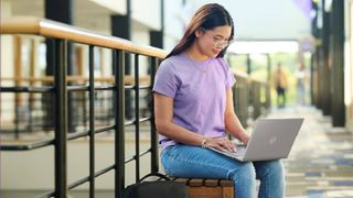 Dell back to school sale student using Dell laptop on school campus