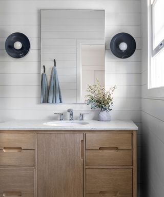 White bathroom with shiplap paneling and a wooden vanity unit