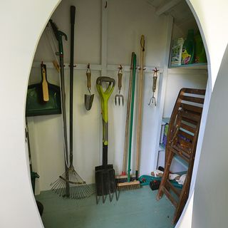 hobbit house with white wall and farming tools