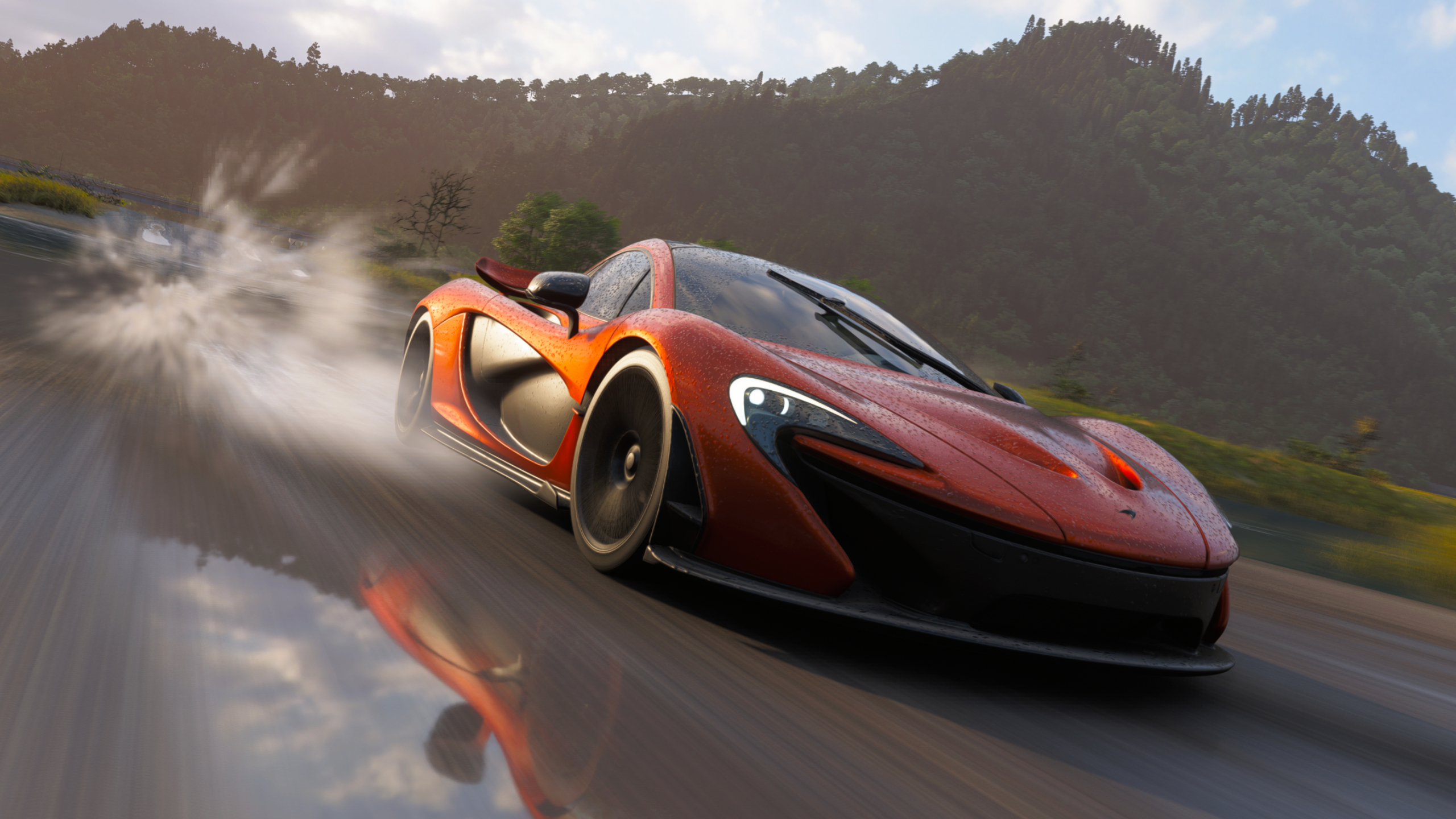 Forza Horizon 6 best cars: A McLaren P1 driving down a wet road towards the camera, spraying water behind it.