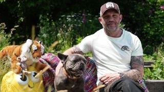 Tom Hardy sits outside with his dog, Blue, for CBeebies Bedtime Stories