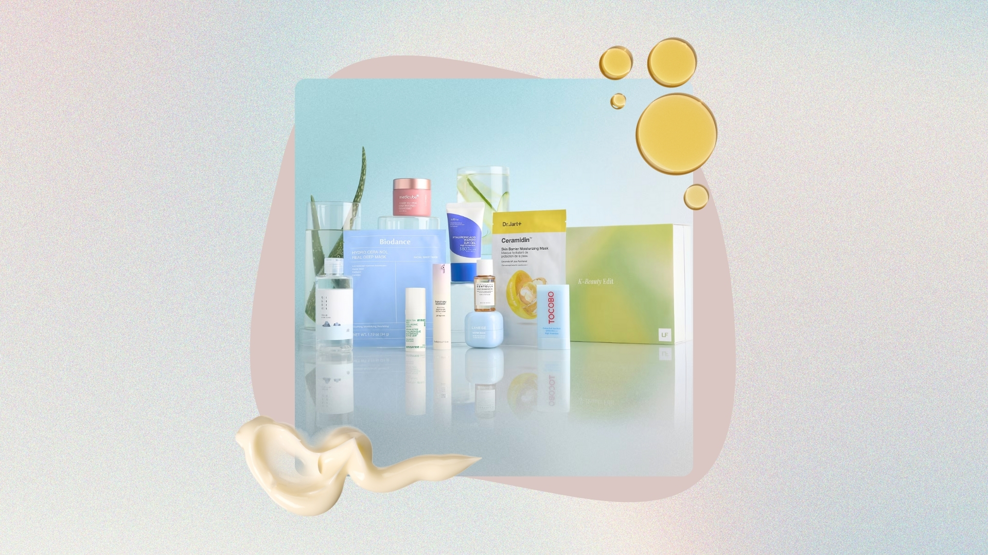 Image of Lookfantastic K Beauty Edit on a pastel watercolour background with pink circle detail, plus swatches of creams and oils