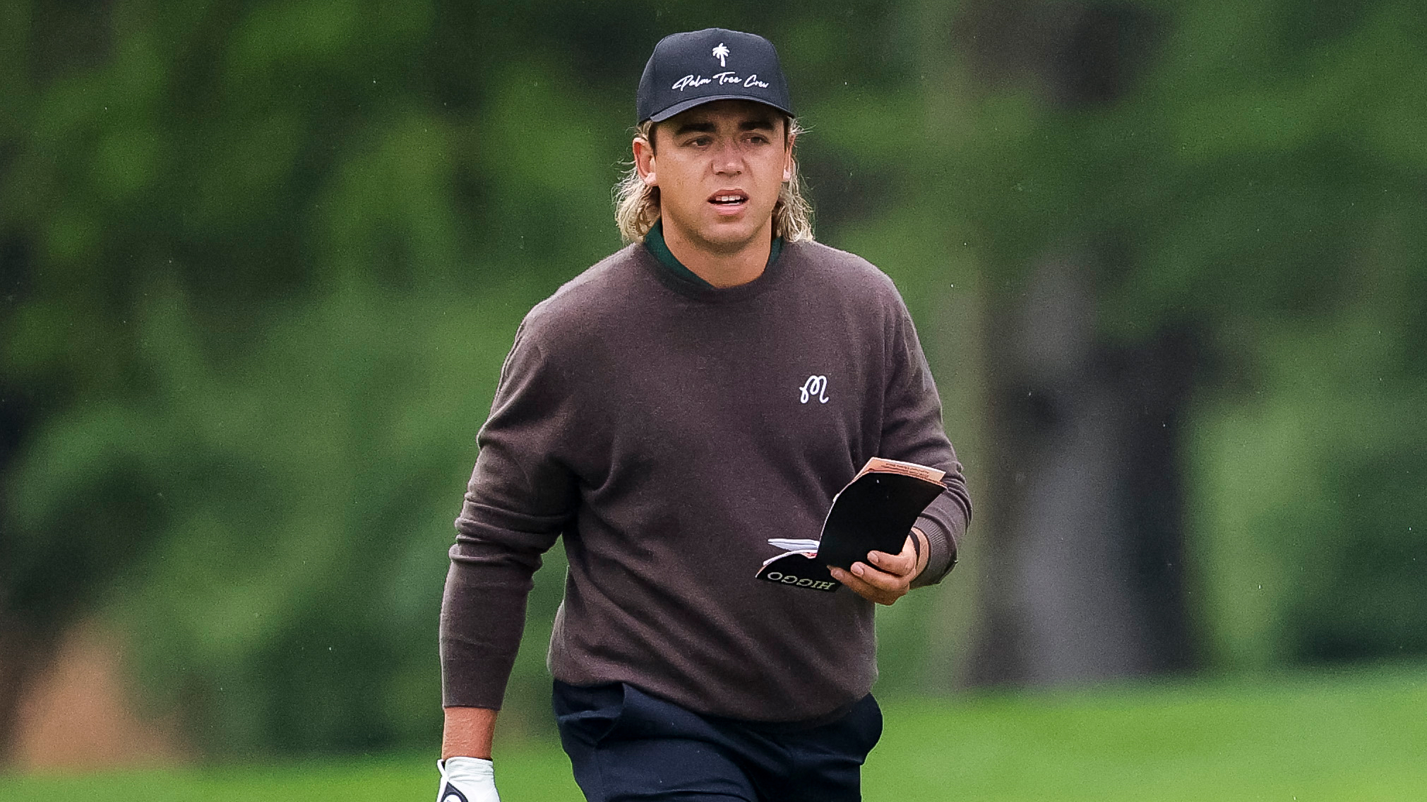Garrick Higgo walking with his yardage book open at the PGA Championship