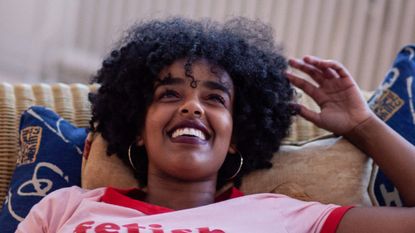 Woman laying in couch smiling - stock photo