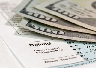 three $100 bills with tax refund form