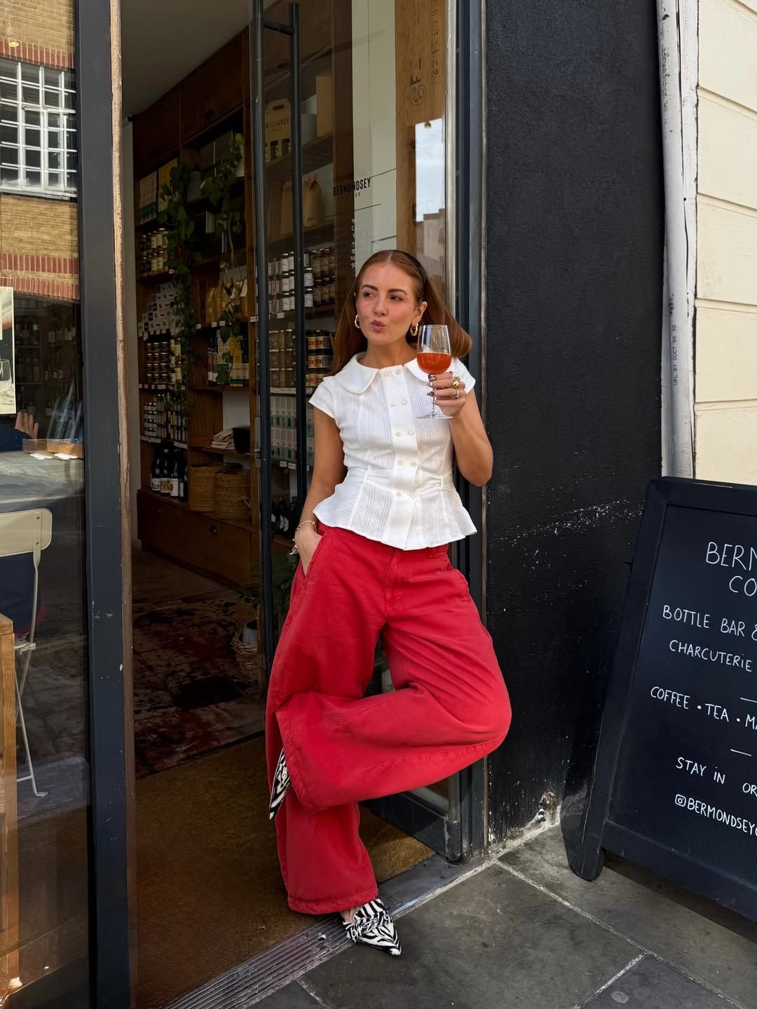 Influencer Rebecca Ferraz Wyatt wearing wide-leg jeans and a fitted shirt.