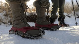 Closeup of winter hiker wearing microspikes in the snow
