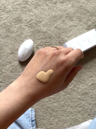 Mica Ricketts showing a swatch of Lisa Eldridge Seamless Skin Enhancing Tint on the back of her hand